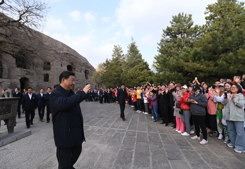 5月11日至12日,中共中央总书记、国家主席、中央军委主席习近平在山西考察。这是5月11日下午,习近平在大同市云冈石窟考察时,向游客们挥手致意。新华社记者 李学仁 摄